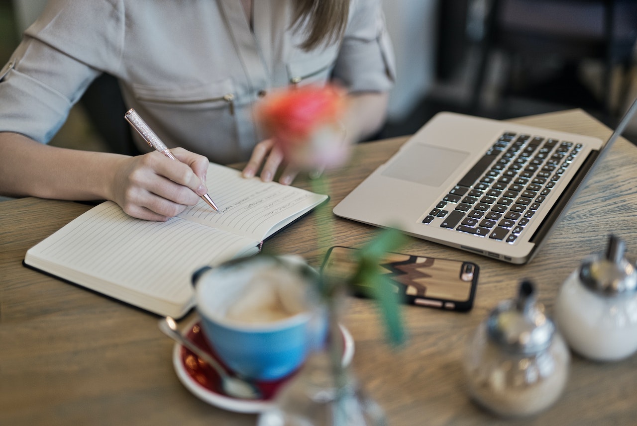 copywriter-freelancer-maria-escreve-copy-redes-sociais Mulher secretária a escrever