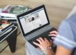 Pessoa a consultar uma página de uma empresa no Facebook através de um portátil.