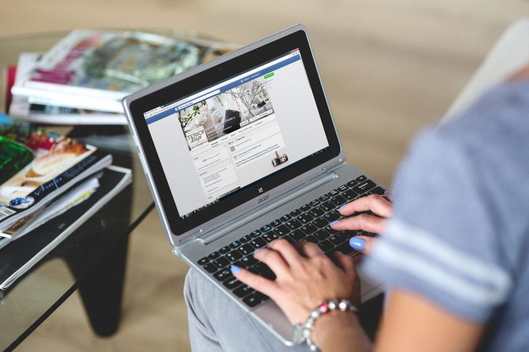 Pessoa a consultar uma página de uma empresa no Facebook através de um portátil.